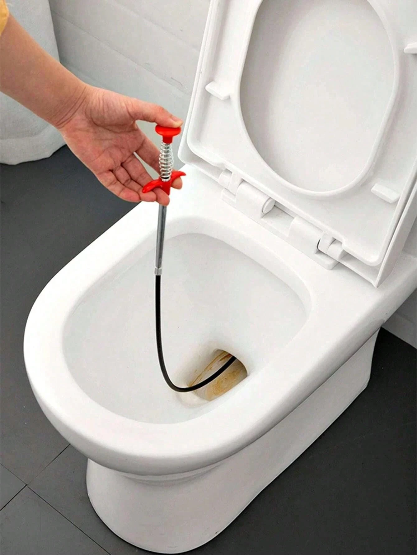 Plumber performing toilet unblocking service in London